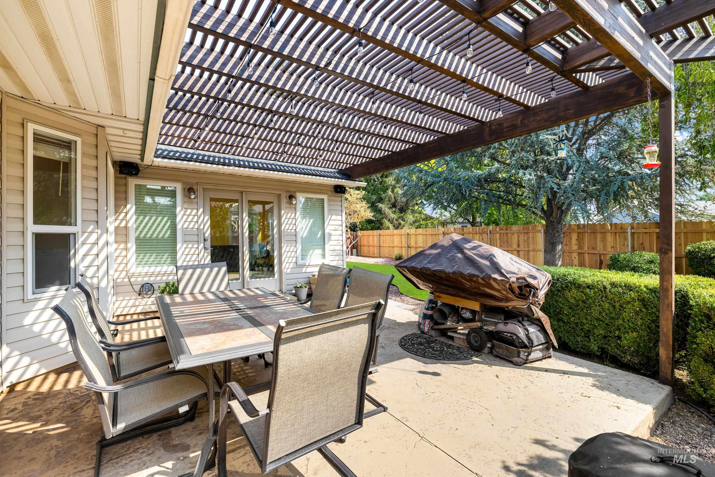 Fenced backyard featuring a patio area, a pergola, and outdoor dining area