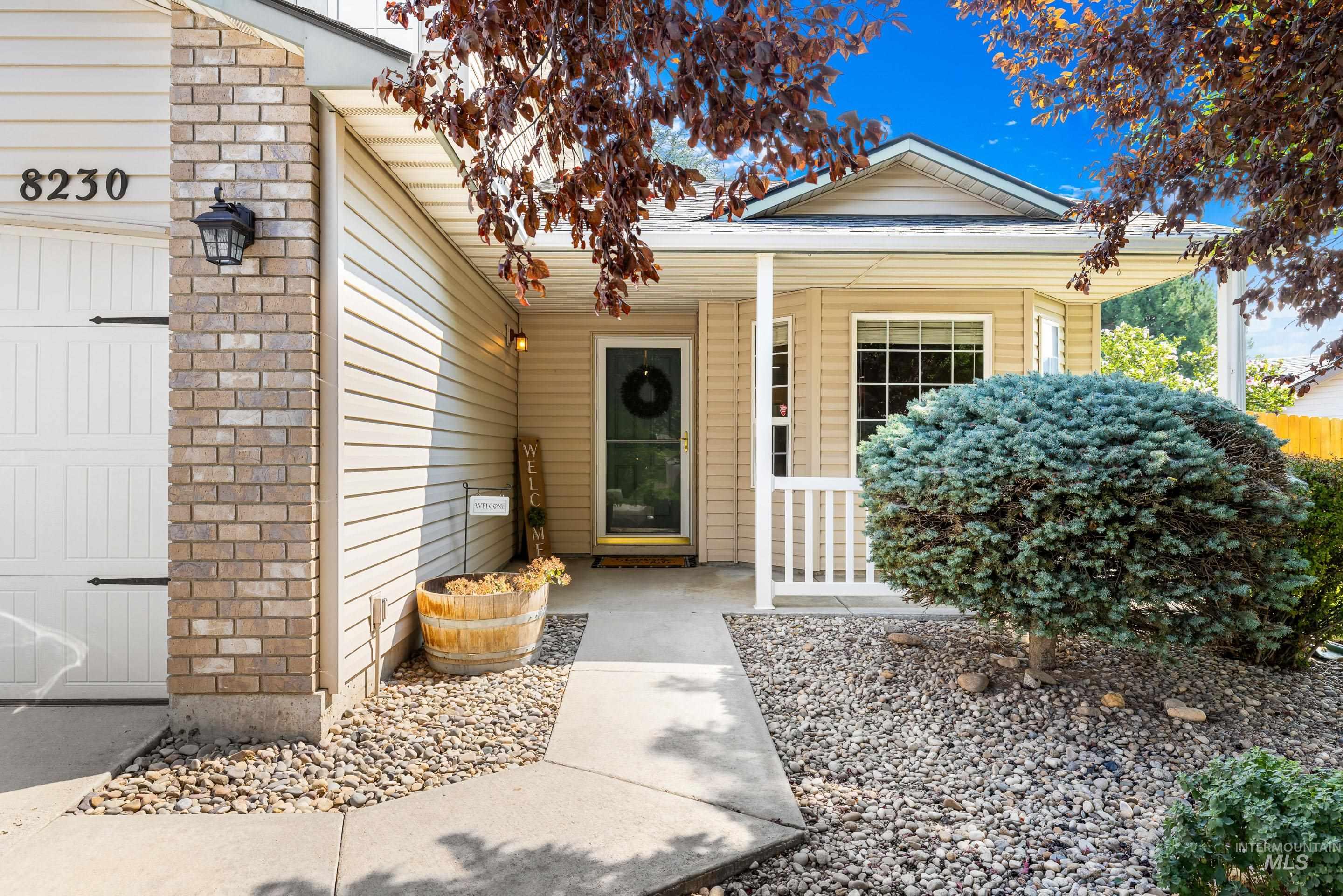 Property entrance featuring covered porch and a garage
