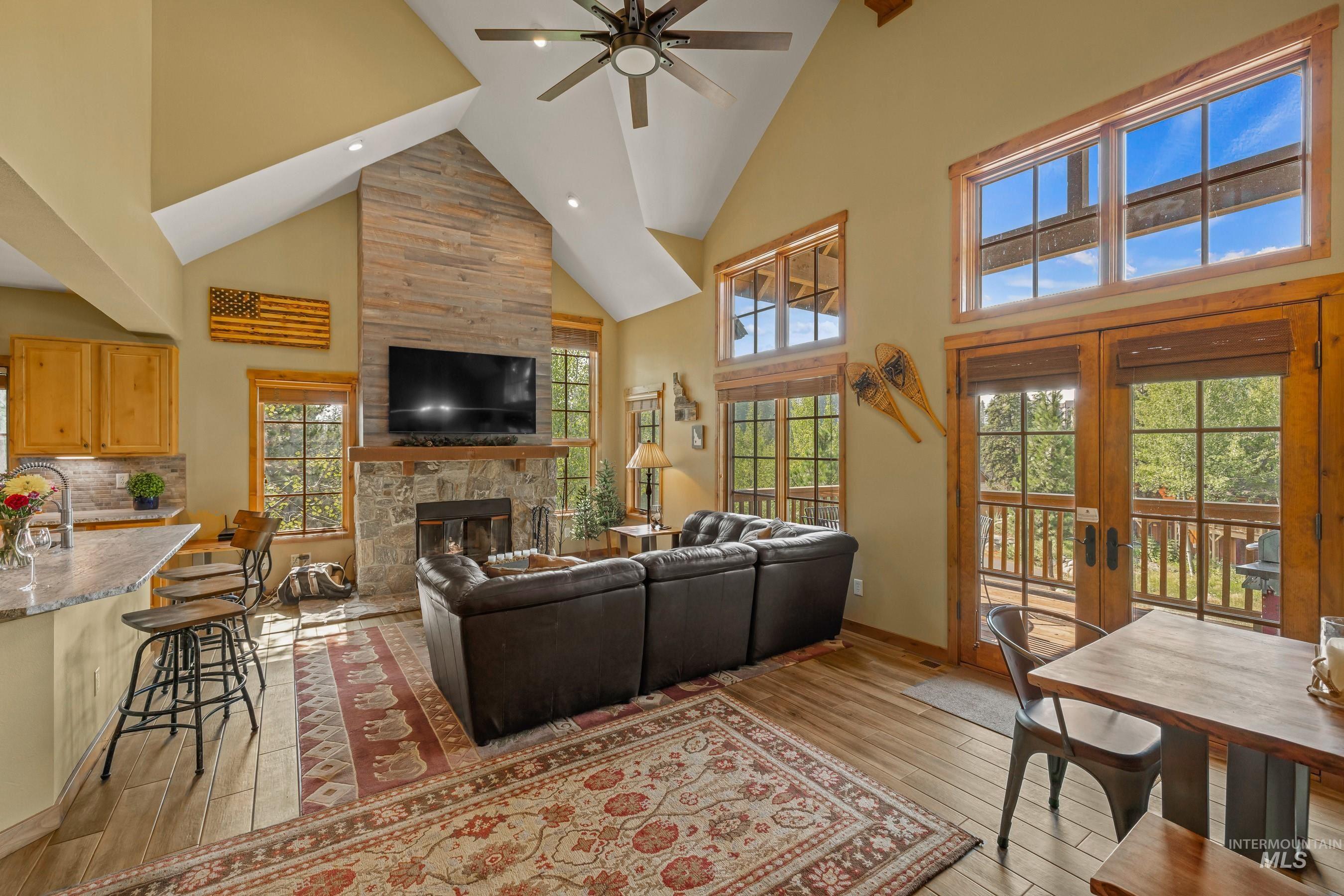 Living area featuring high vaulted ceiling, a fireplace, newly finished floors, recessed lighting, and ceiling fan