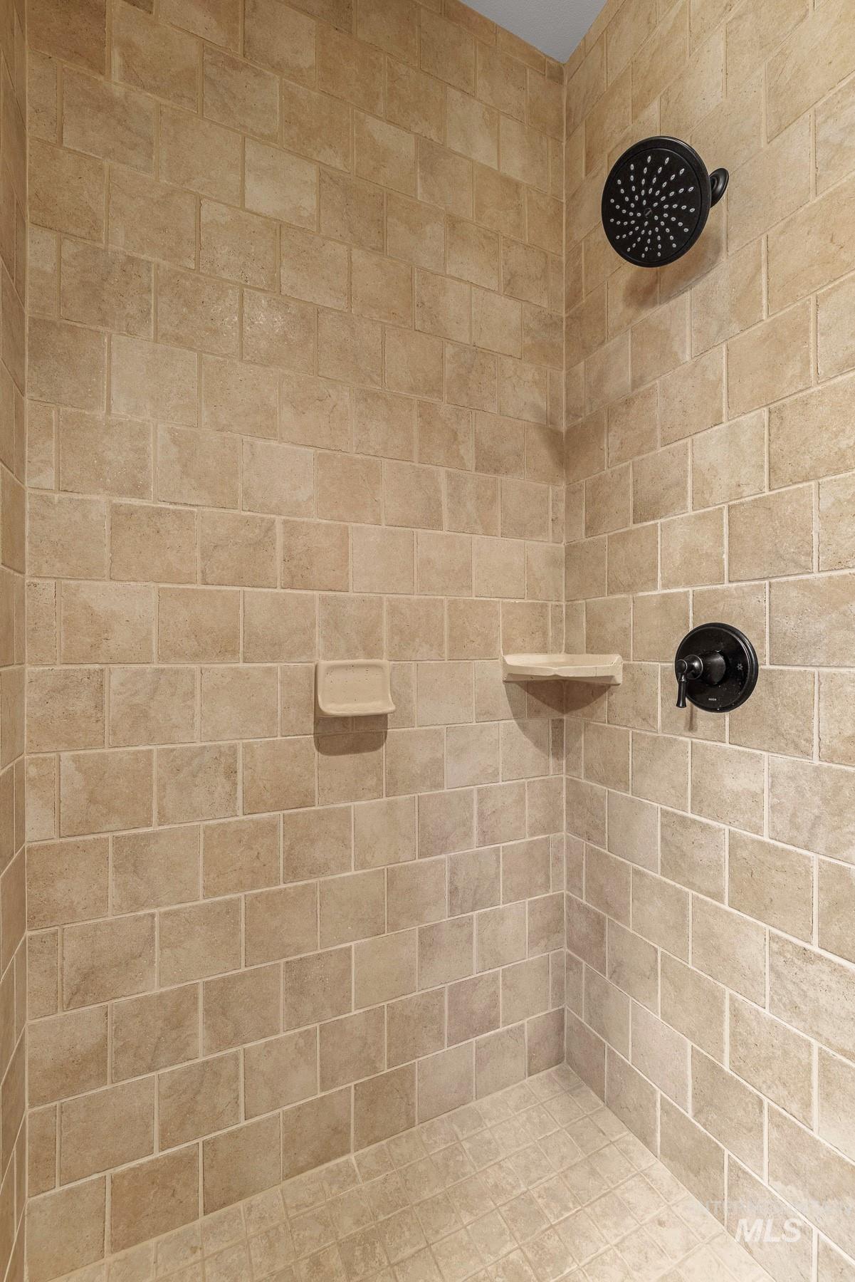 Main level bathroom featuring a tile shower