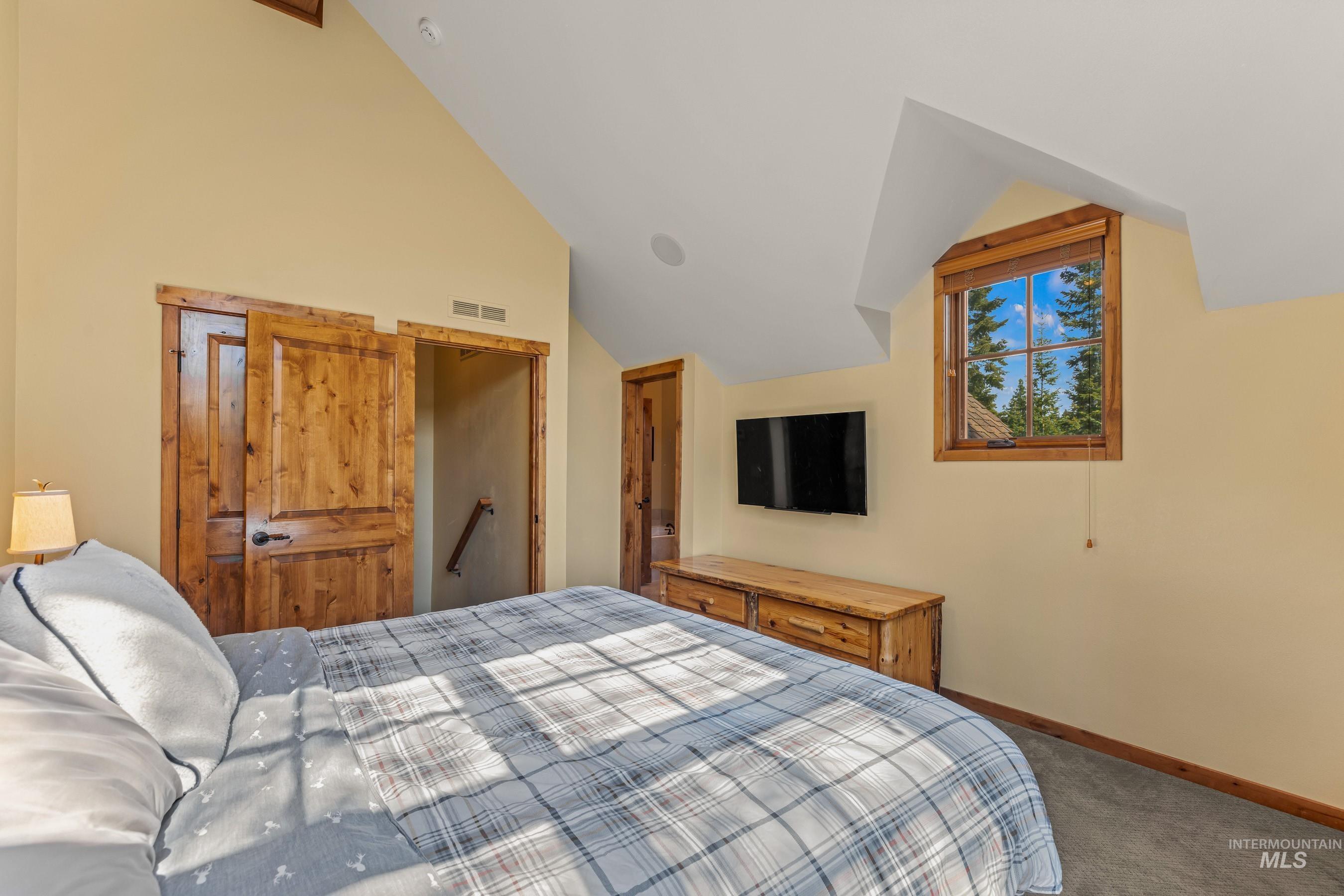 Newly carpeted primary with lofted ceiling
