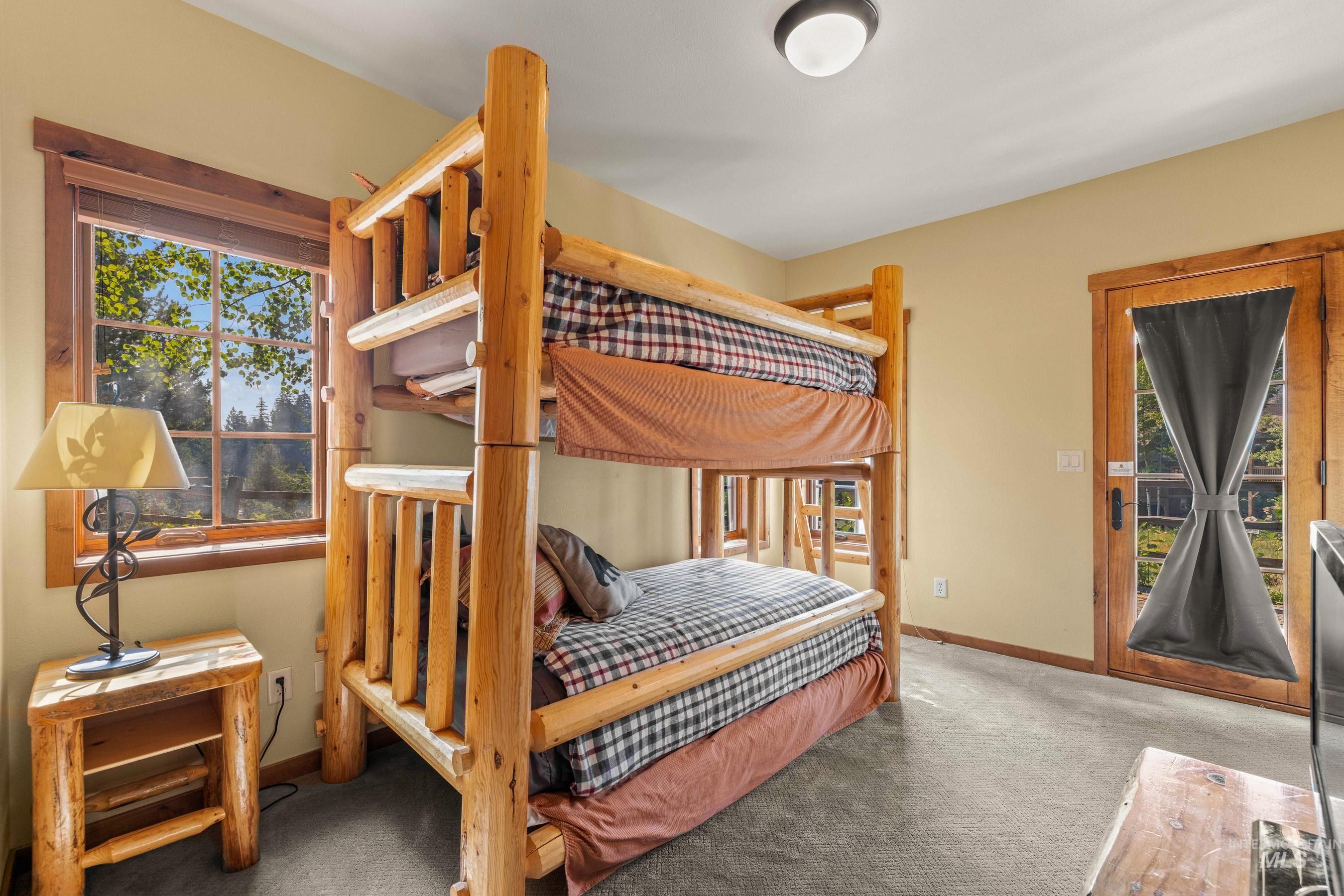 Carpeted bedroom with access to exterior and baseboards