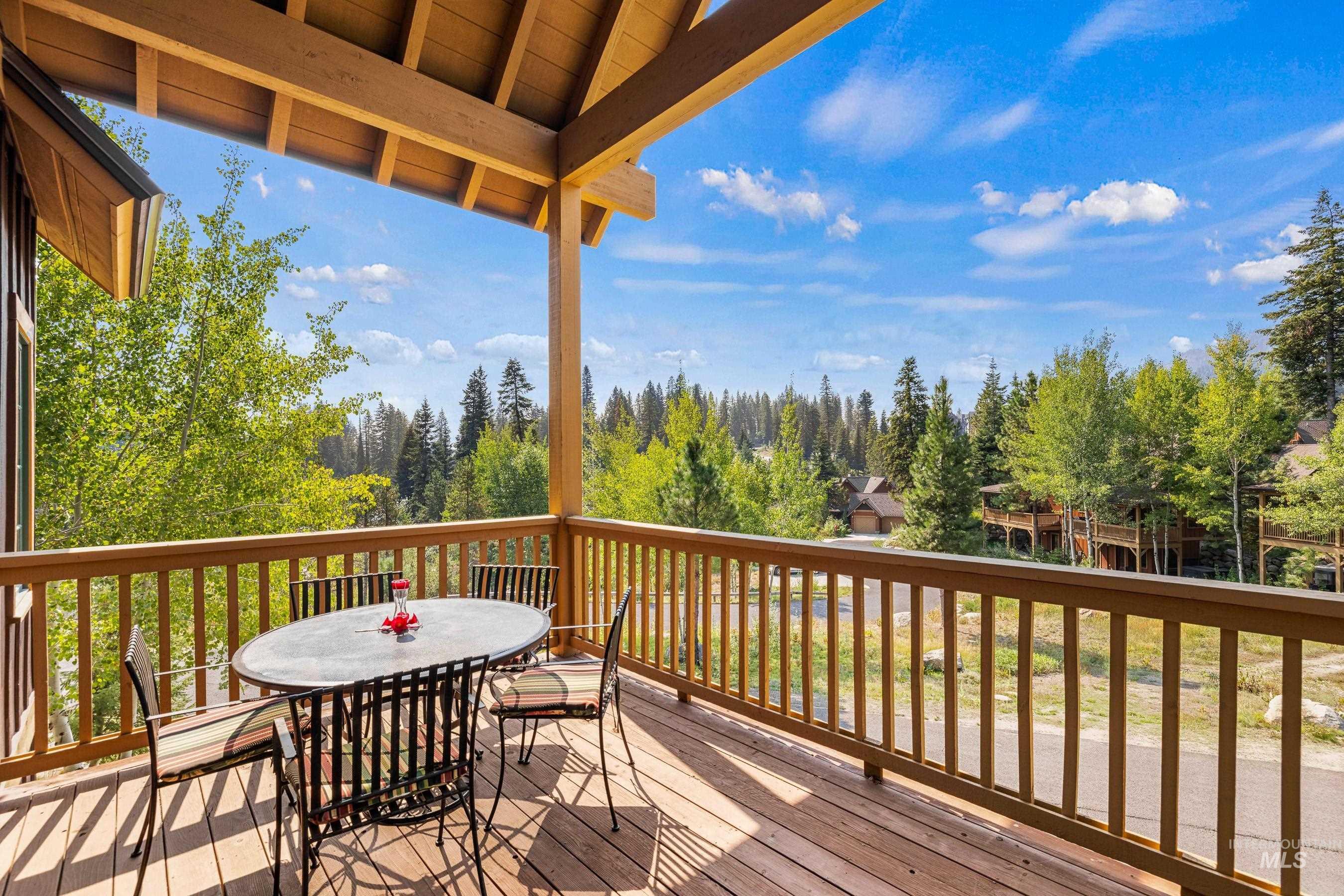 Wooden deck with outdoor dining space and view of the area