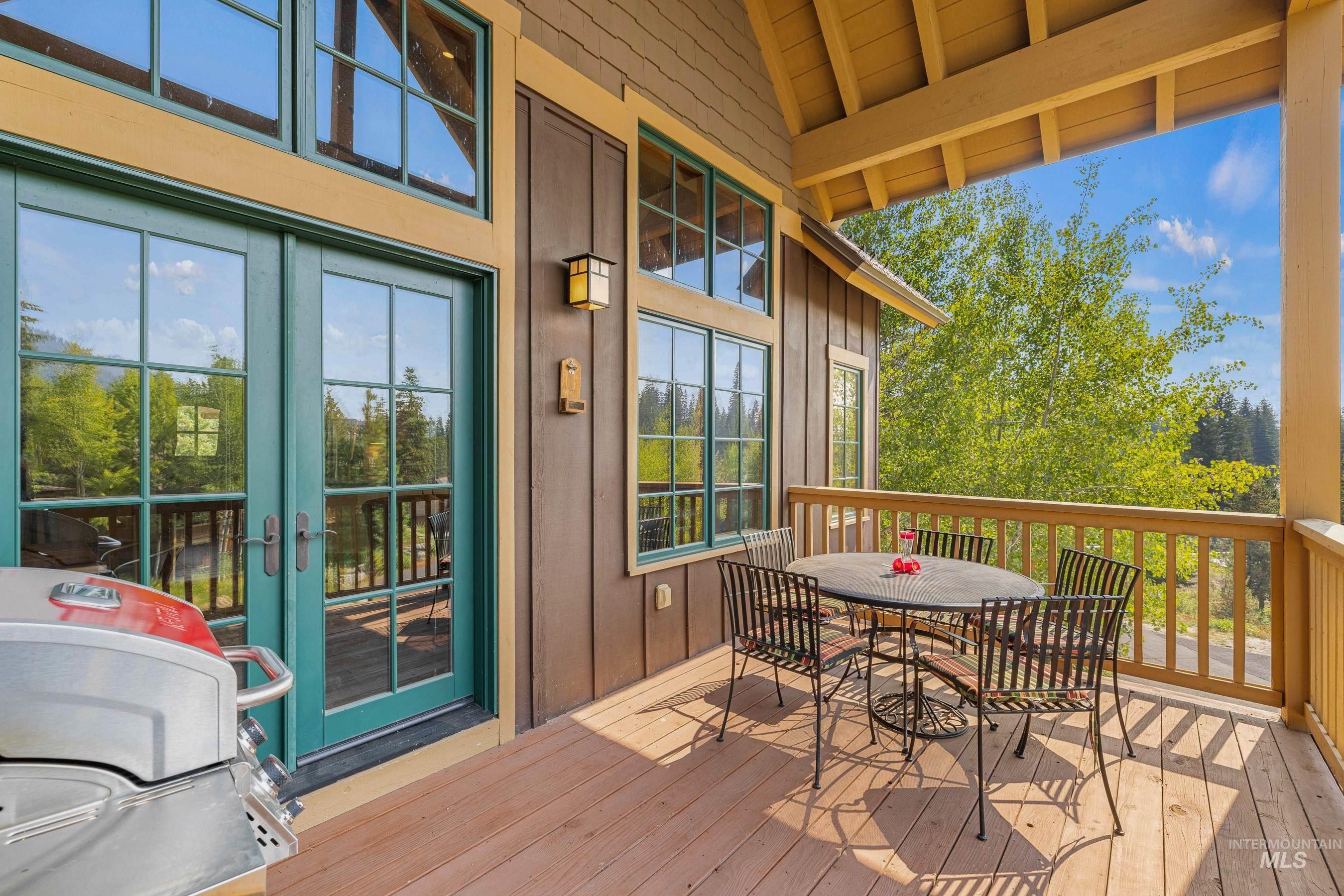 Wooden terrace with outdoor dining area and french doors