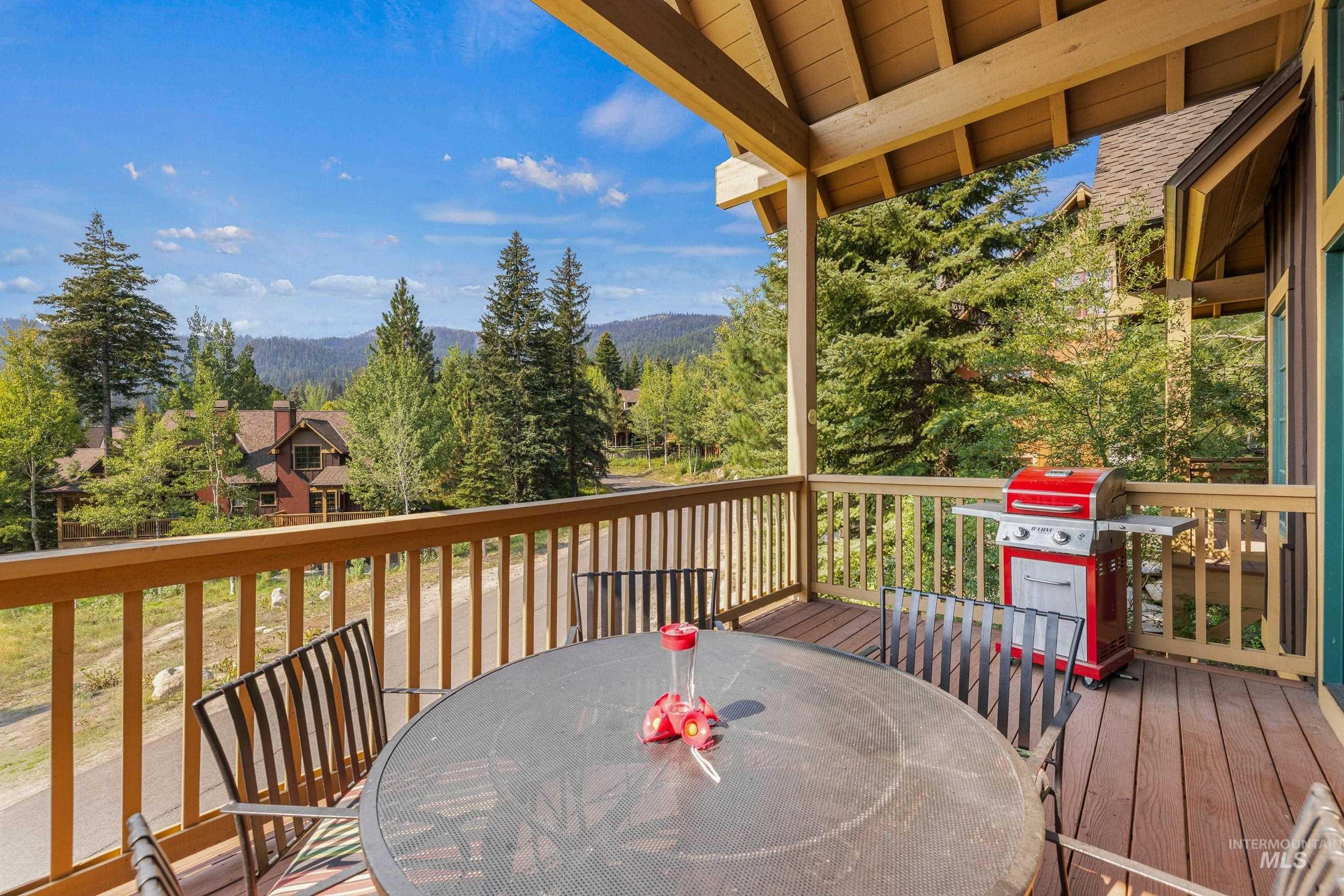 Wooden deck featuring outdoor dining area, area for grilling, and a mountain view