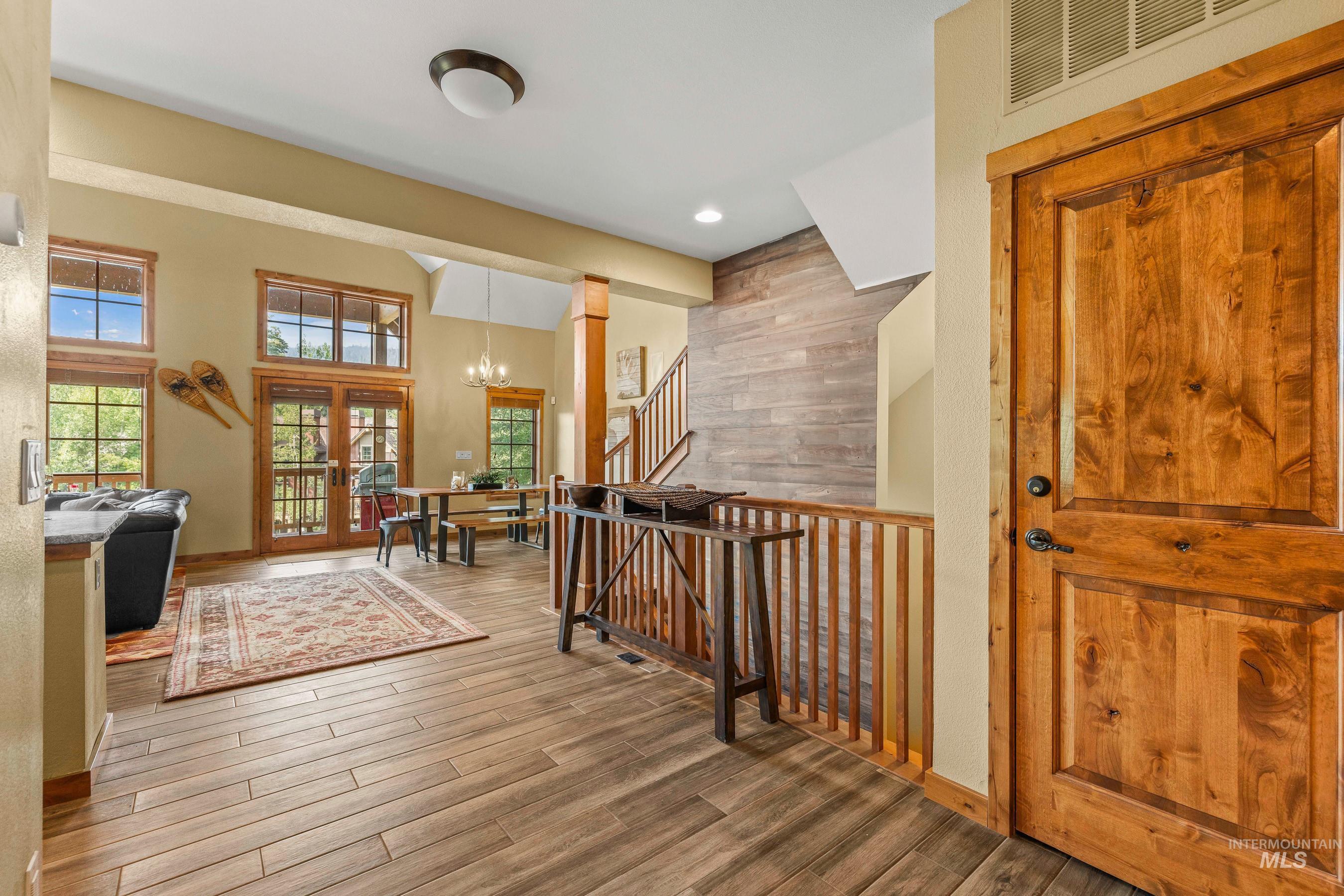 Entrance foyer with a chandelier, newly finished tile floors, stairs, and recessed lighting