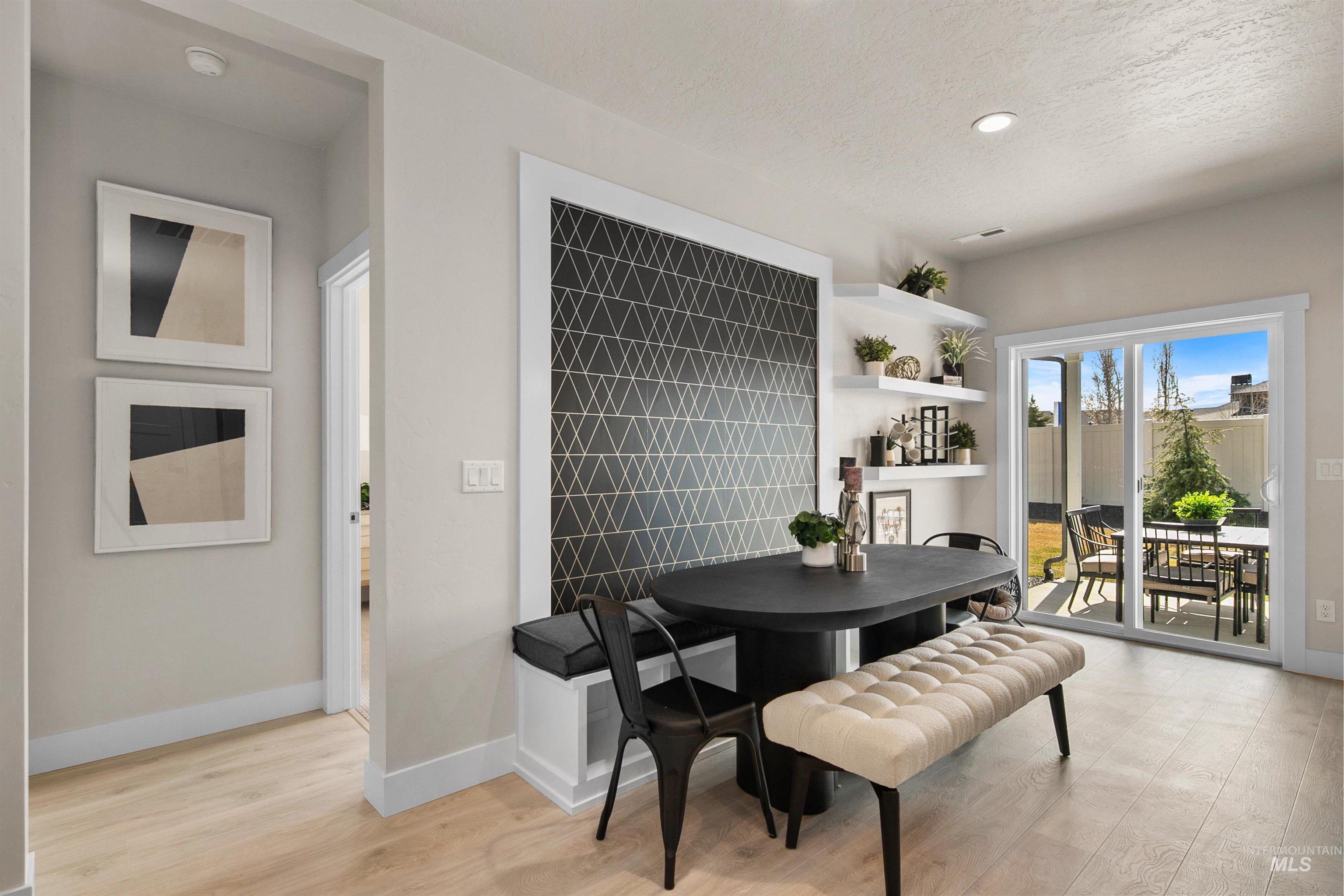Dining area with light wood finished floors, recessed lighting, and a textured ceiling