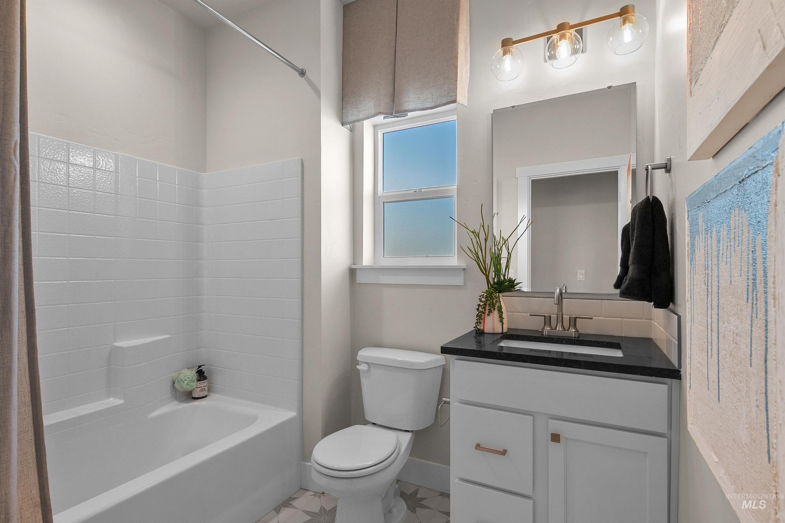 Full bathroom with vanity, bathtub / shower combination, and light tile patterned floors