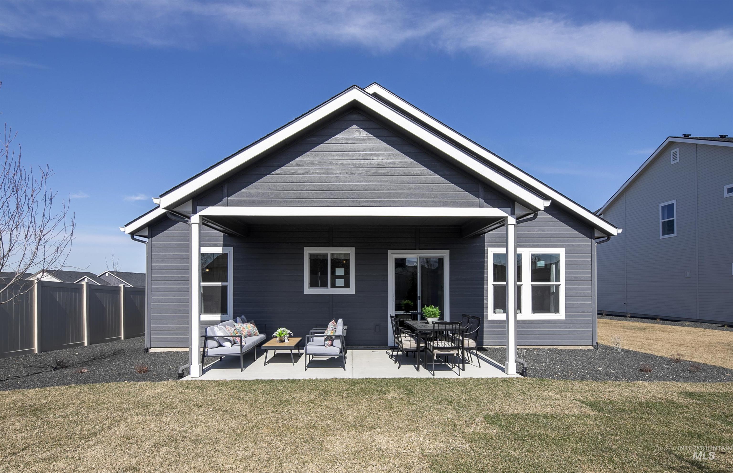 Back of property with an outdoor living space, a lawn, and a patio area