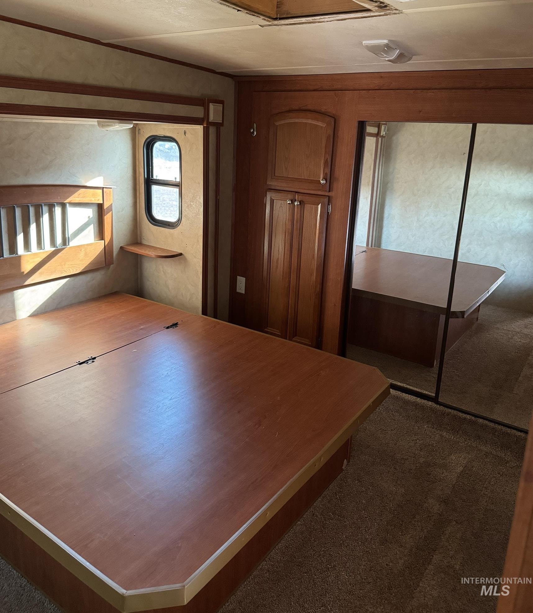 Unfurnished bedroom with dark carpet