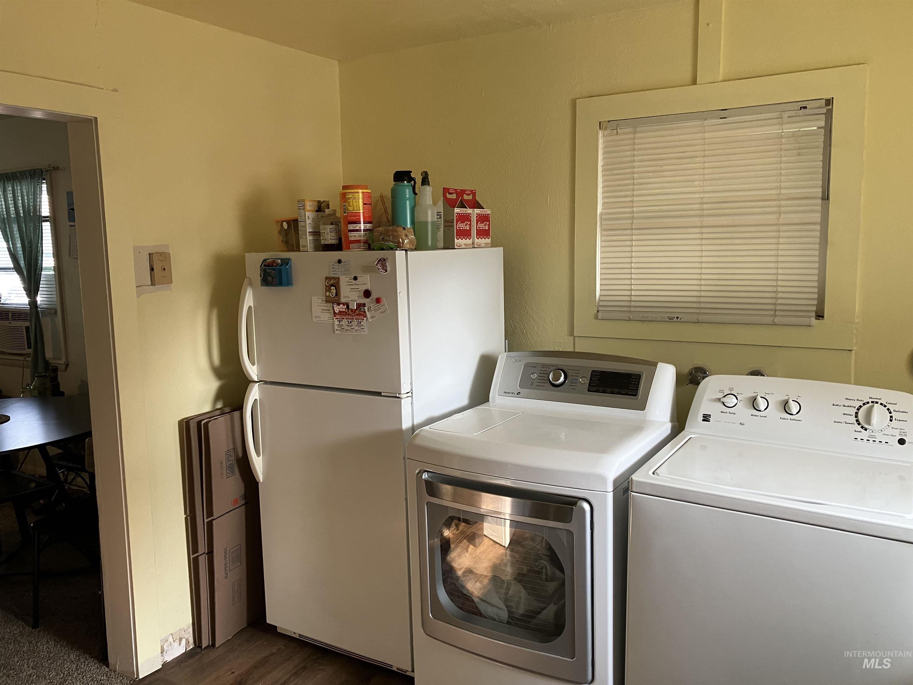 Washroom featuring separate washer and dryer and dark wood-type flooring