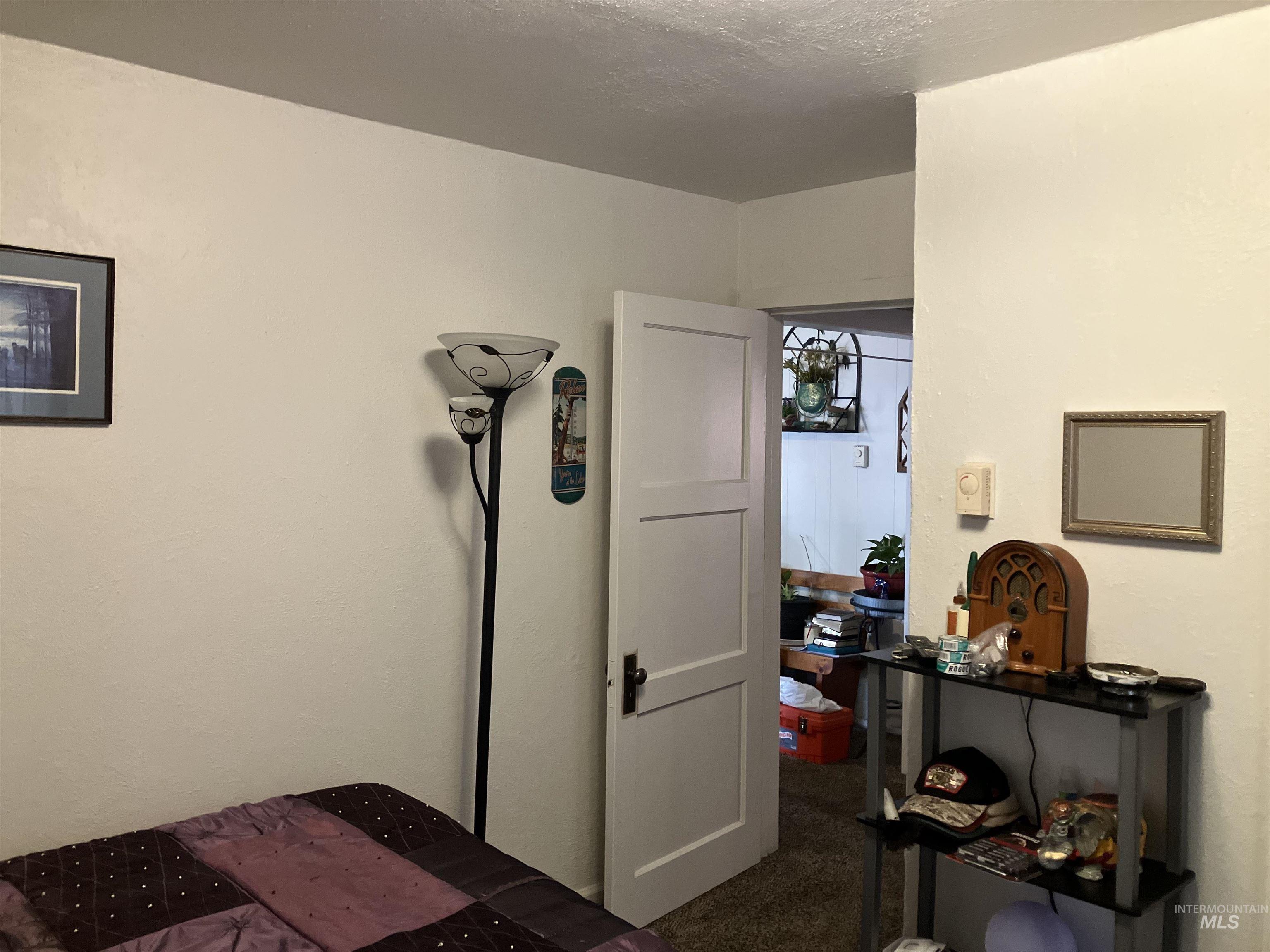 Bedroom featuring dark colored carpet and a textured ceiling