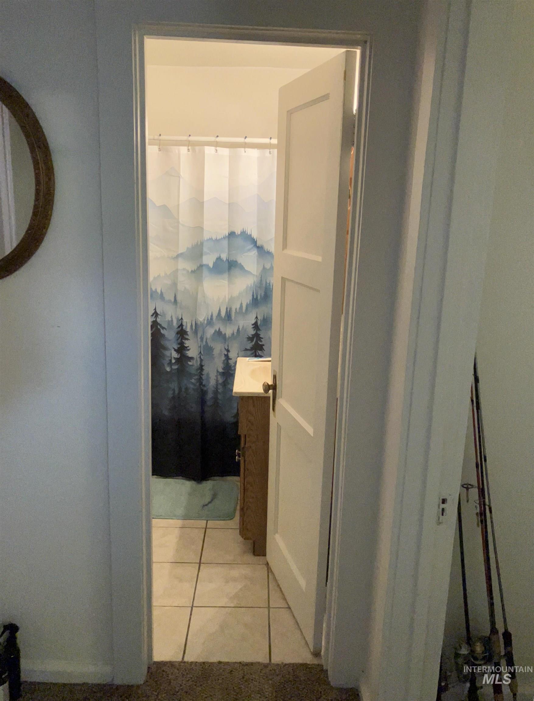 Bathroom with light tile patterned flooring, vanity, and curtained shower