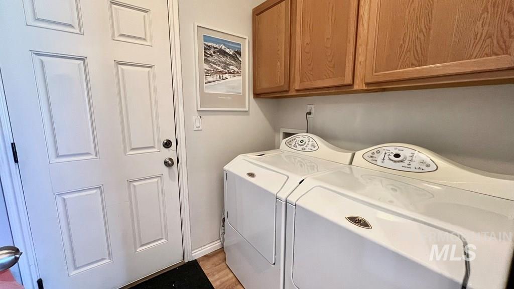 Washroom featuring independent washer and dryer and cabinet space