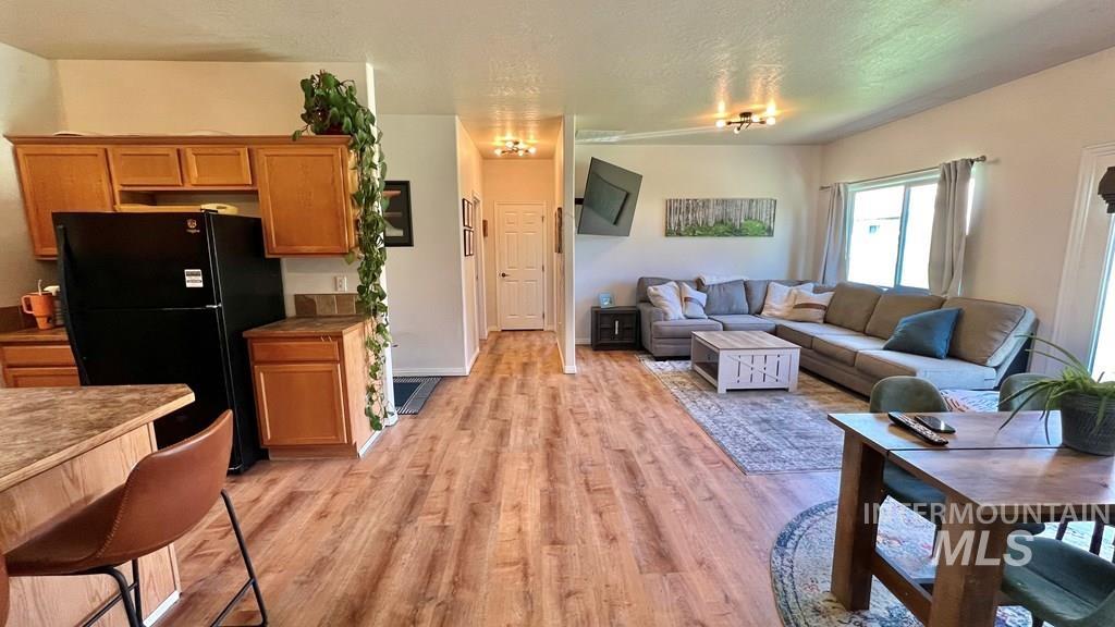 Living room with light wood-type flooring and a textured ceiling