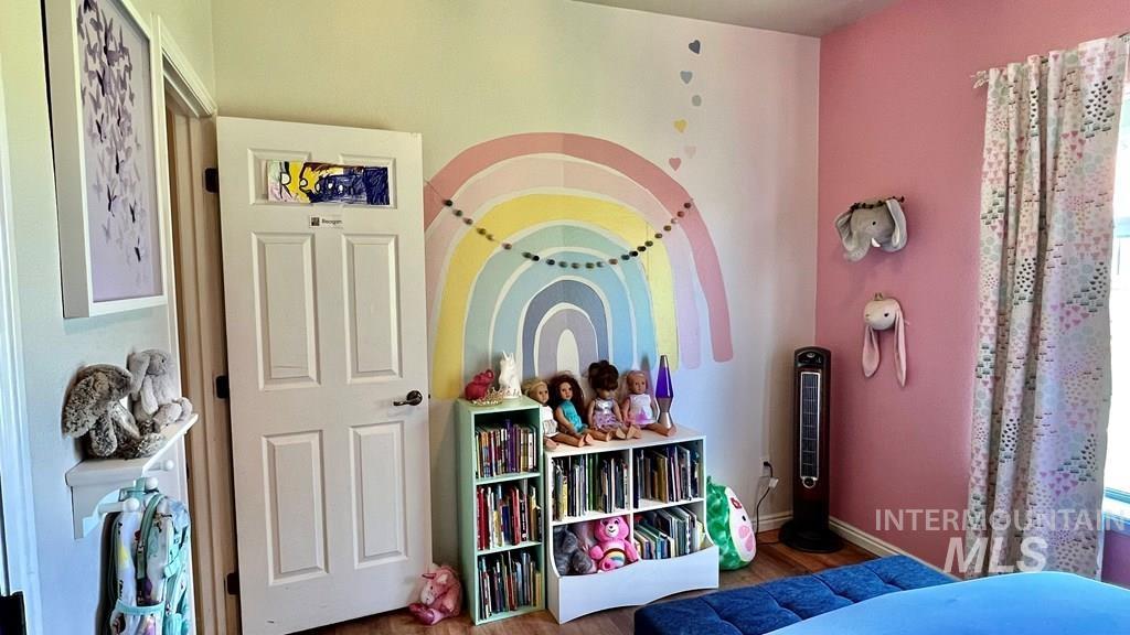 Bedroom with wood finished floors and baseboards