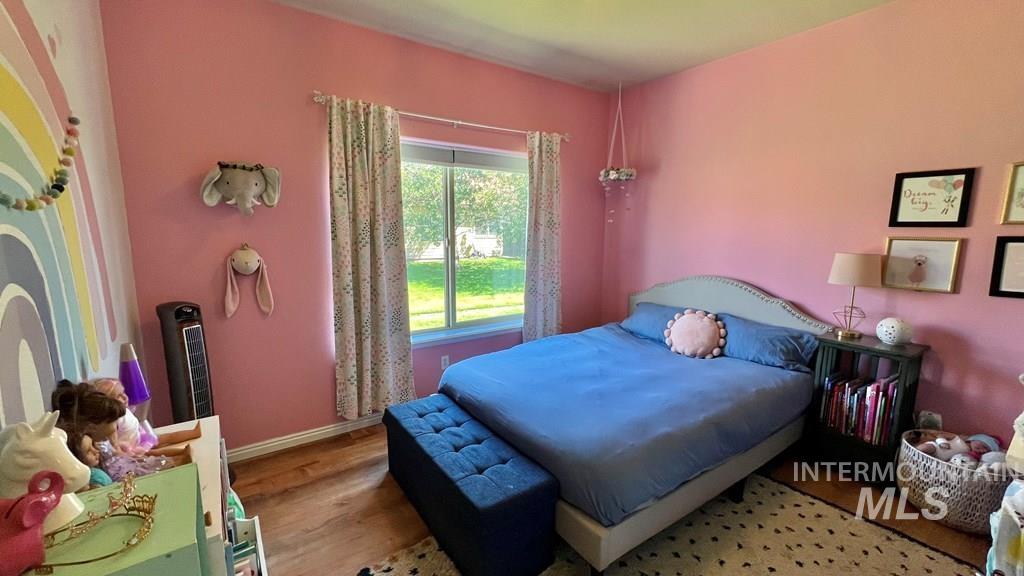 Bedroom with wood finished floors and baseboards