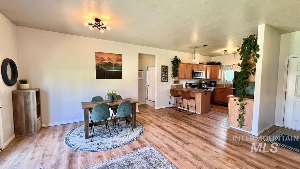 Dining space featuring light wood-style flooring and a textured ceiling