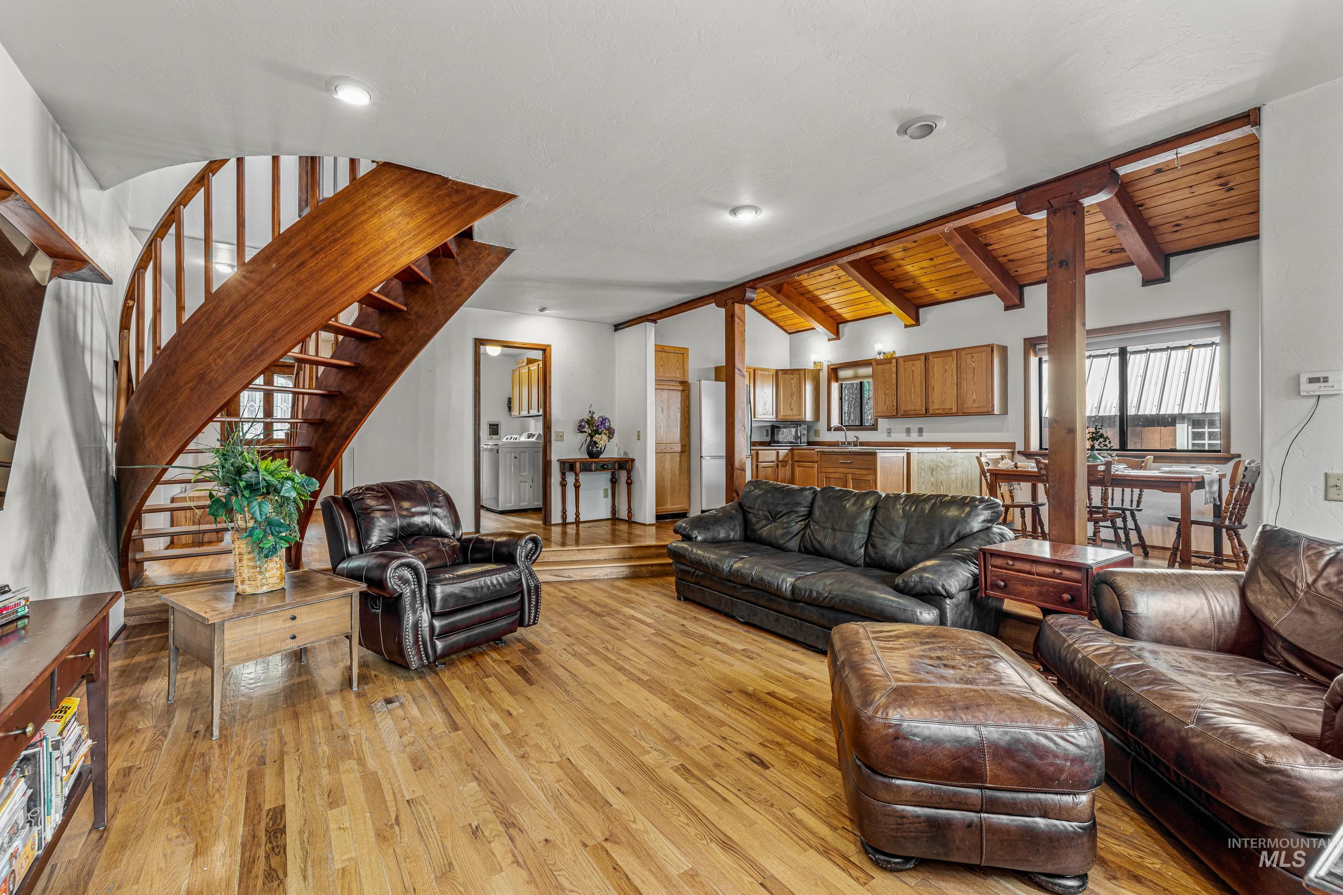 Living room featuring light wood-style flooring, stairway, and wood ceiling