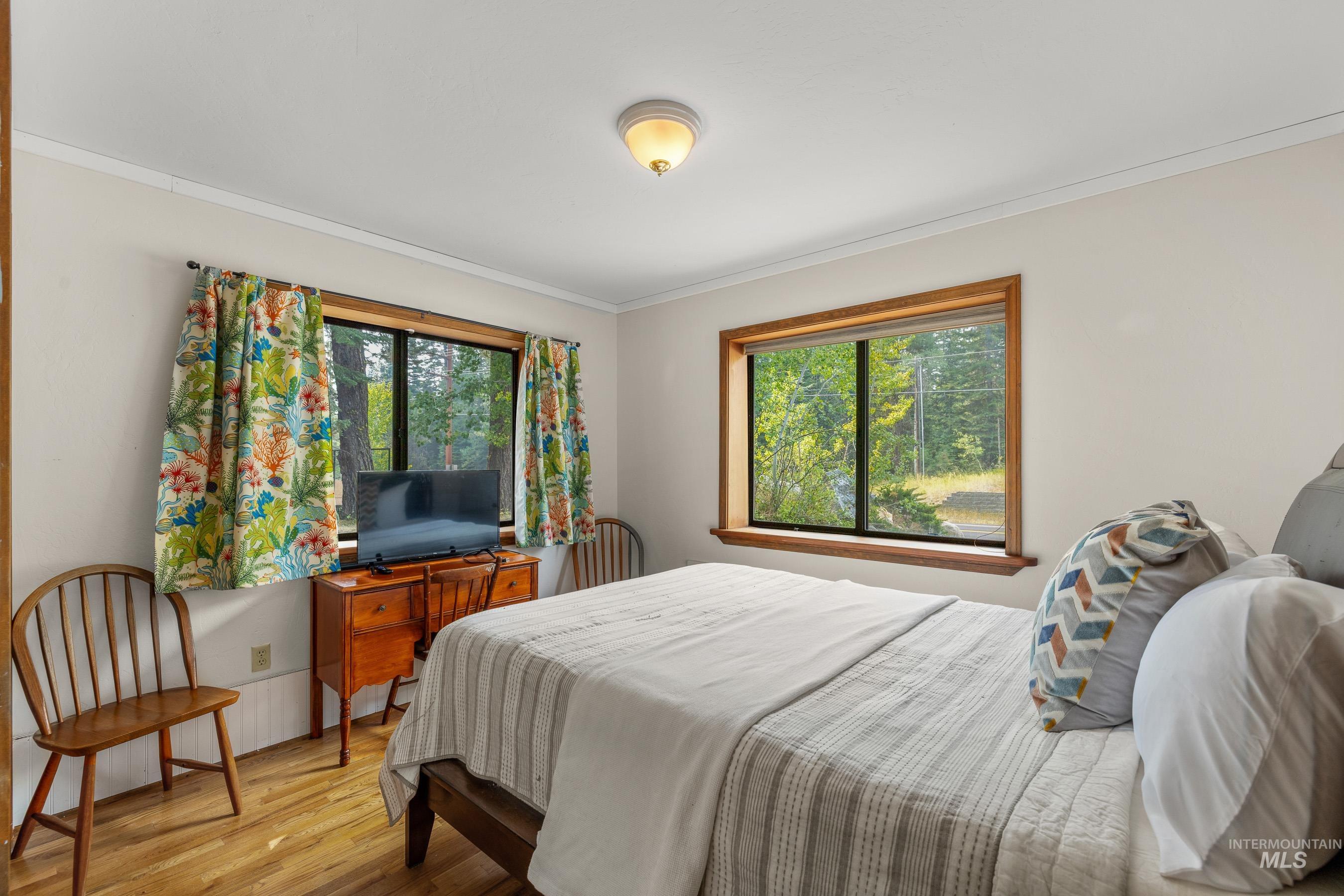 Bedroom featuring wood finished floors and ornamental molding