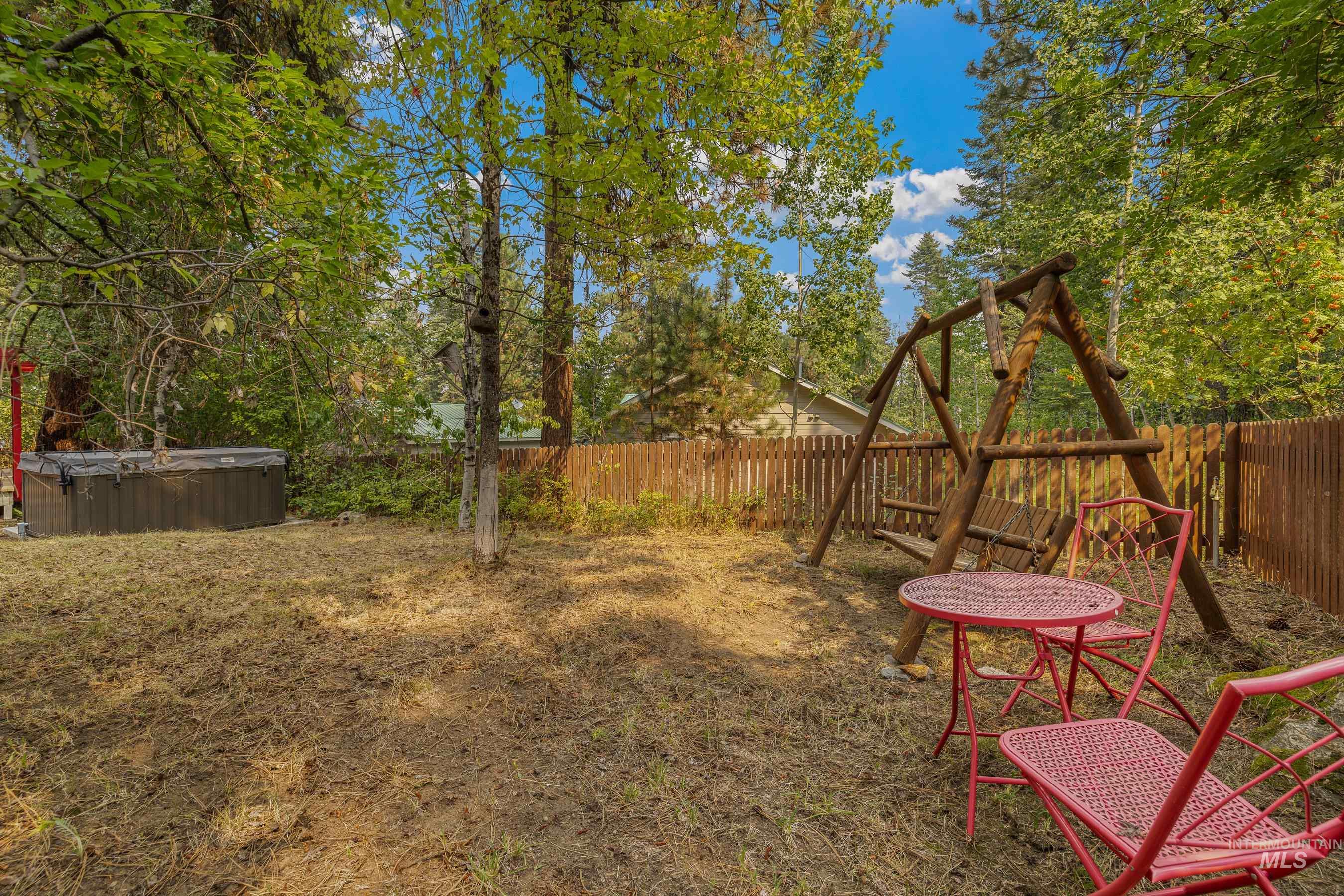Fenced backyard with a hot tub
