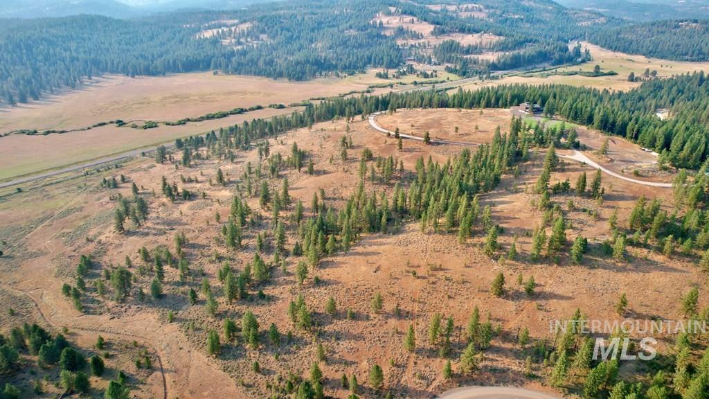 Aerial view of property and surrounding area with a heavily wooded area