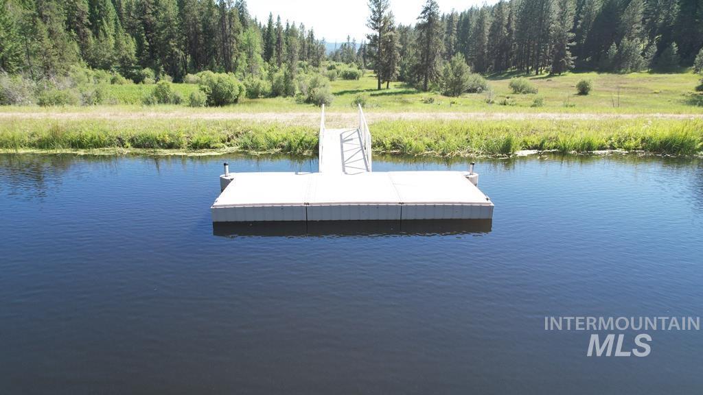 Dock with a water view and a wooded view