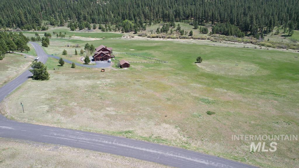 Aerial view of property and surrounding area with a forest