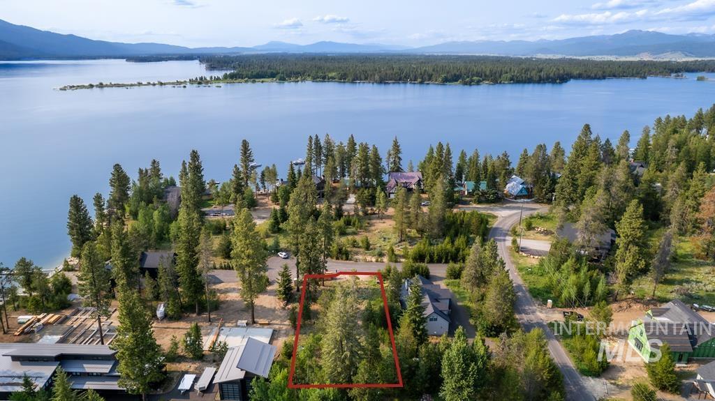Aerial view of property and surrounding area featuring a water and mountain view and property parcel outlined