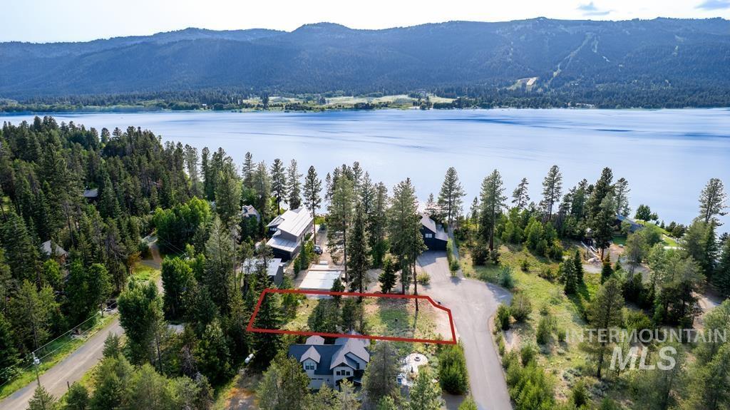 Aerial overview of property's location featuring property parcel outlined and a water and mountain view