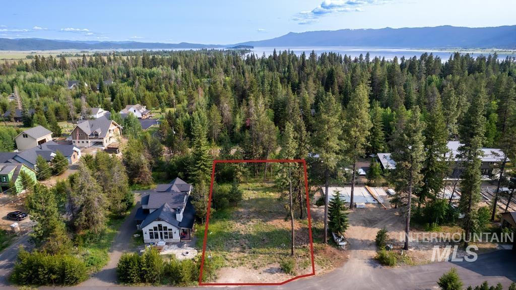Aerial overview of property's location with a mountain backdrop and property boundaries highlighted