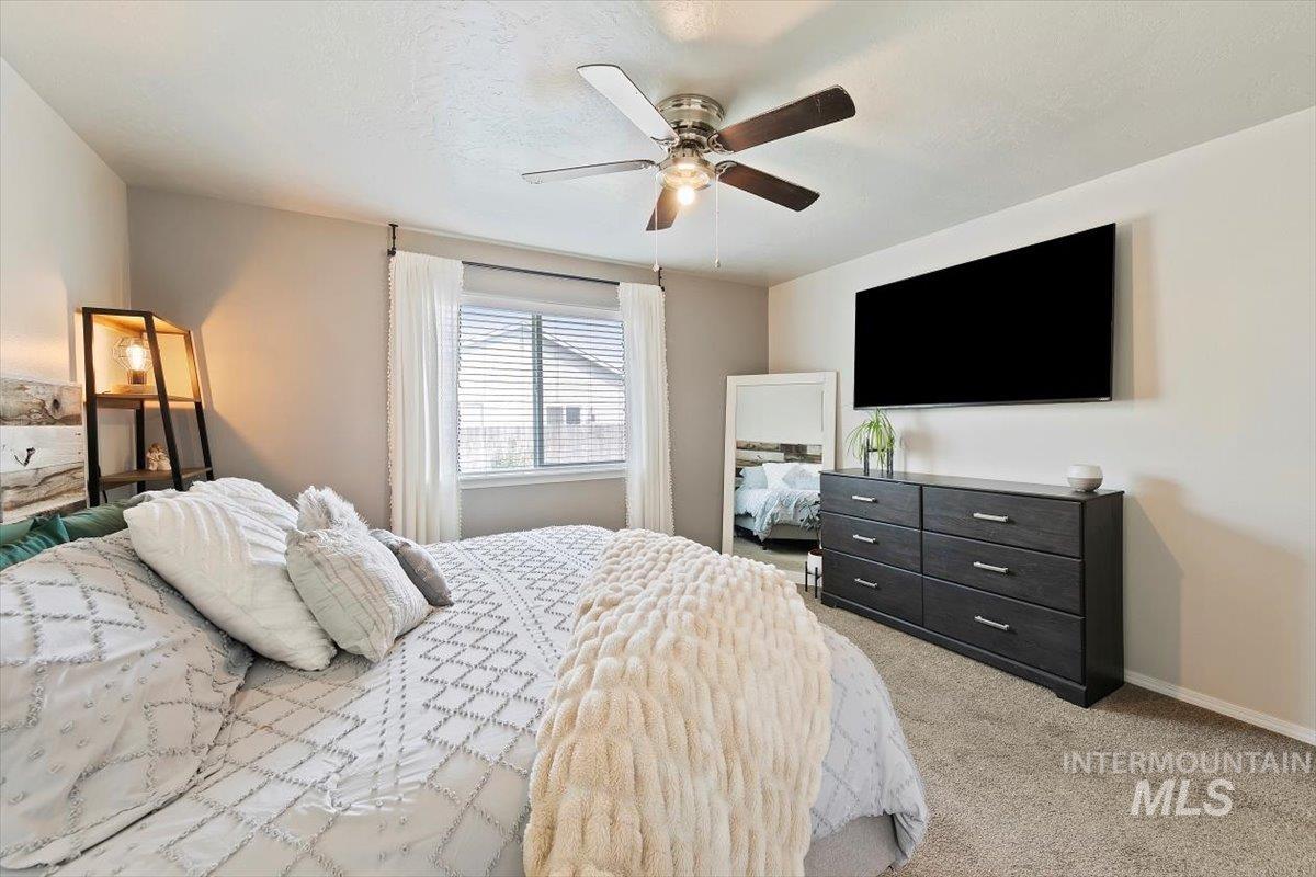 Bedroom featuring light carpet and a ceiling fan