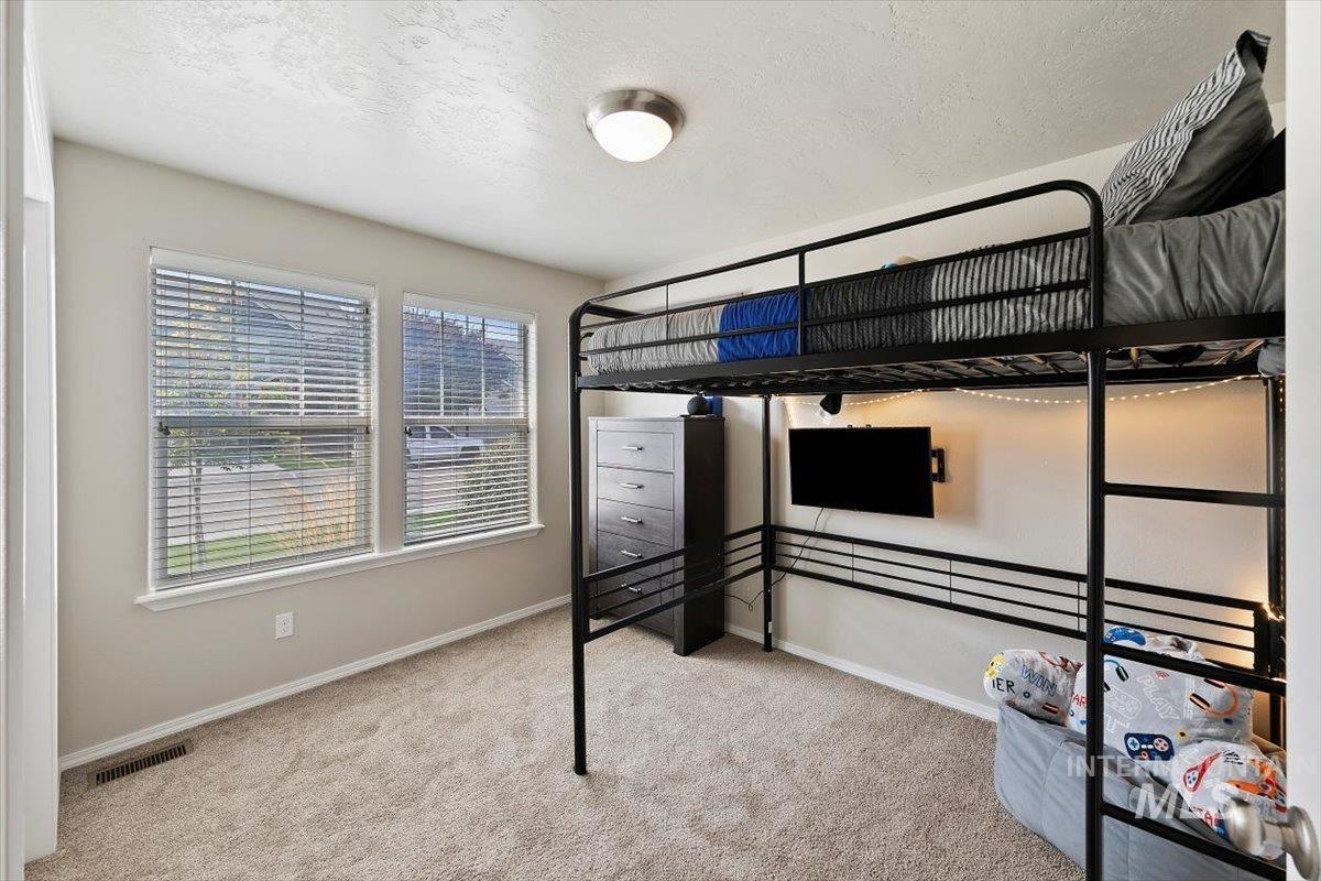 Unfurnished bedroom featuring a textured ceiling and light colored carpet