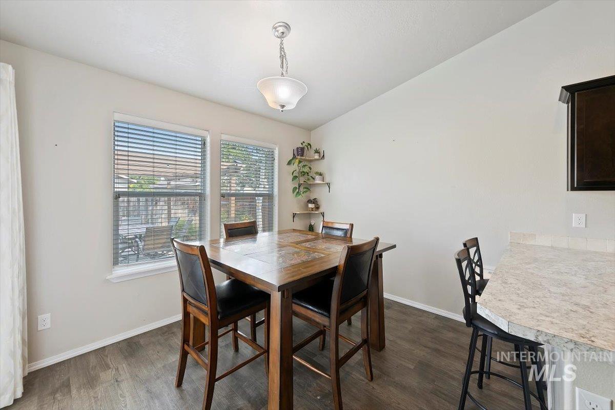 Dining space featuring baseboards and dark wood-type flooring
