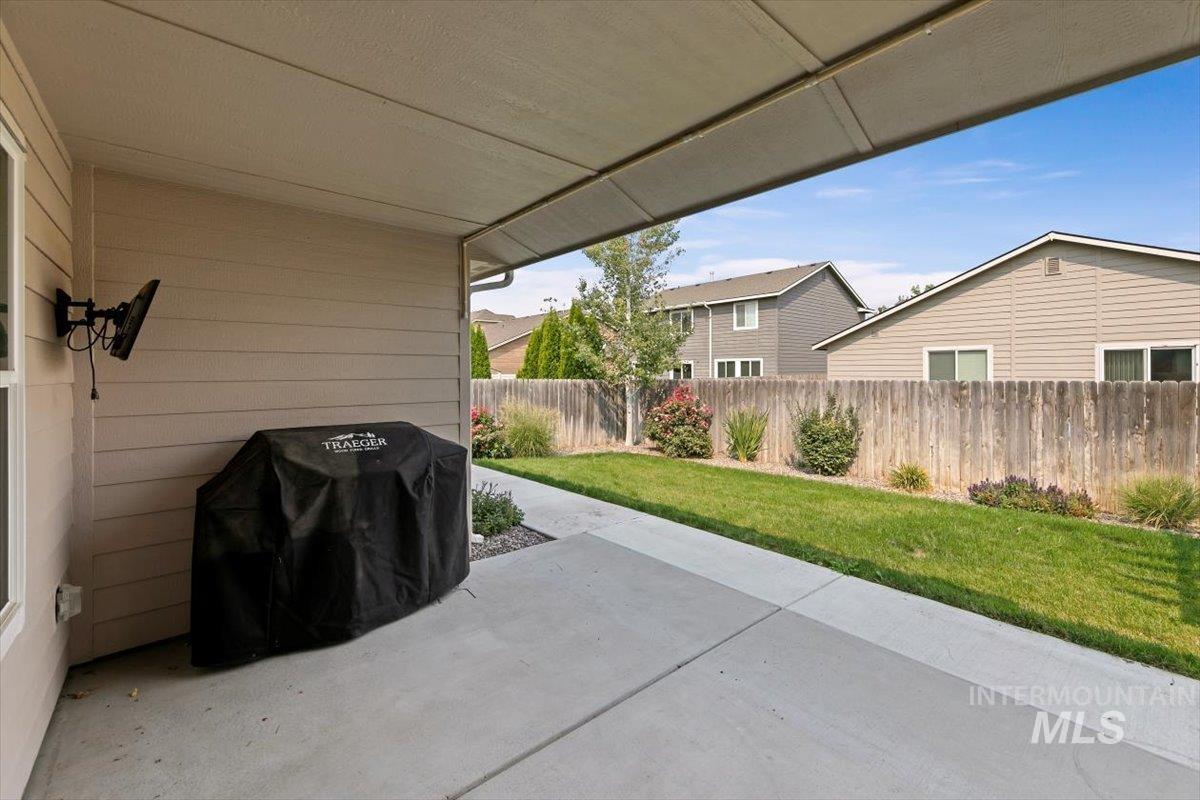Fenced backyard featuring a patio and grilling area