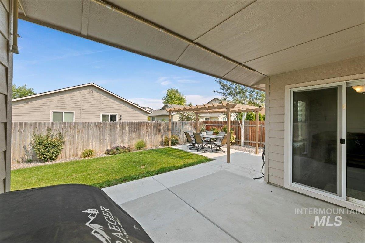 Fenced backyard with a patio area, a pergola, and outdoor dining space