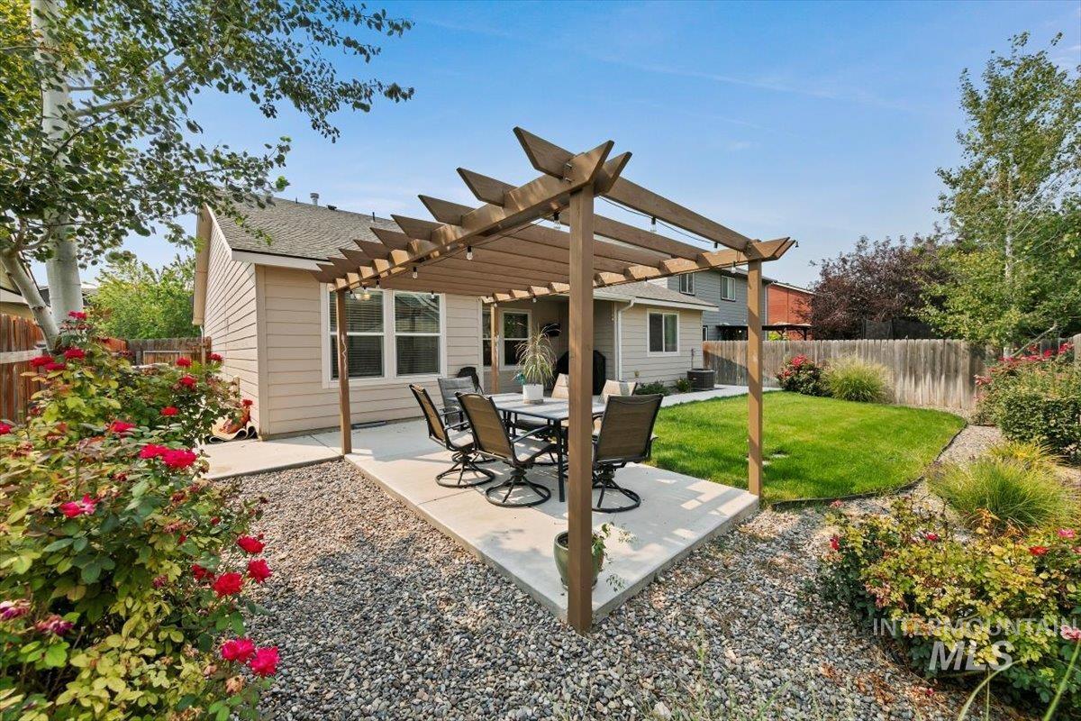 Back of property with a pergola, a patio area, a fenced backyard, and a shingled roof