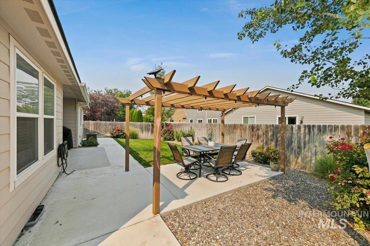 Fenced backyard featuring a patio, a pergola, and outdoor dining area