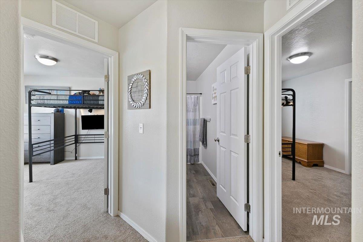 Corridor featuring light carpet and baseboards