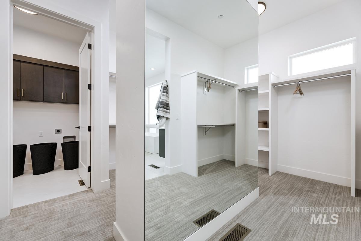 Walk in closet featuring light colored carpet
