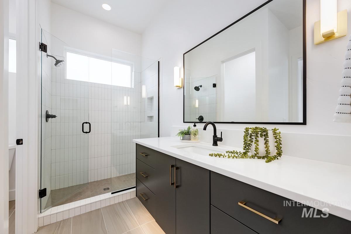 Bathroom with vanity, a stall shower, light tile patterned floors, and recessed lighting