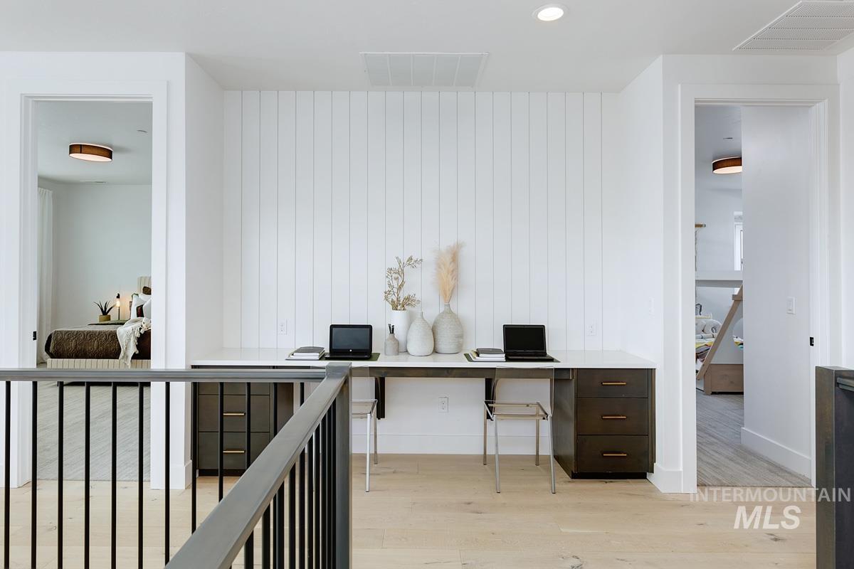 Office space with light wood-type flooring and recessed lighting