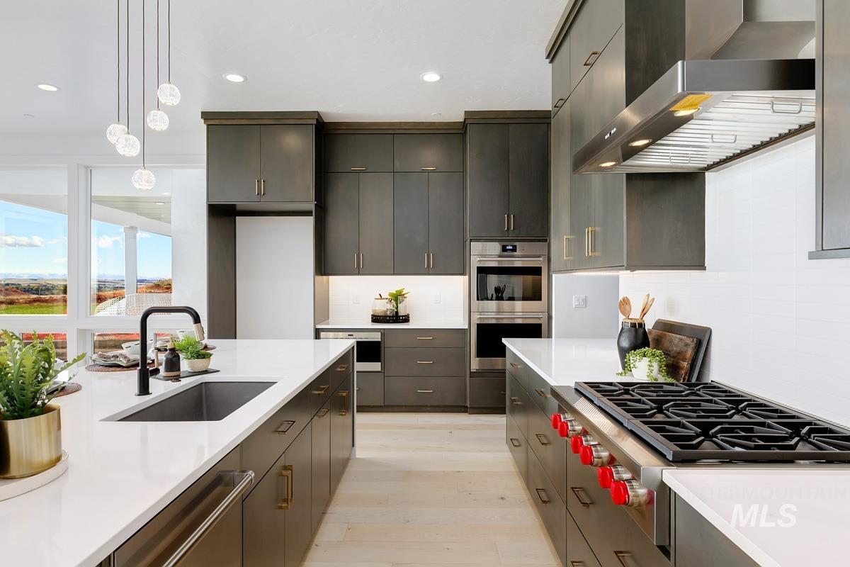 Kitchen with wall chimney range hood, appliances with stainless steel finishes, decorative light fixtures, recessed lighting, and tasteful backsplash