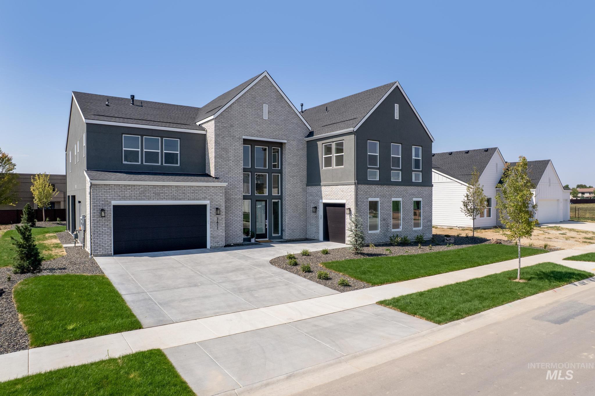 View of front of house featuring brick siding, an attached garage, and driveway