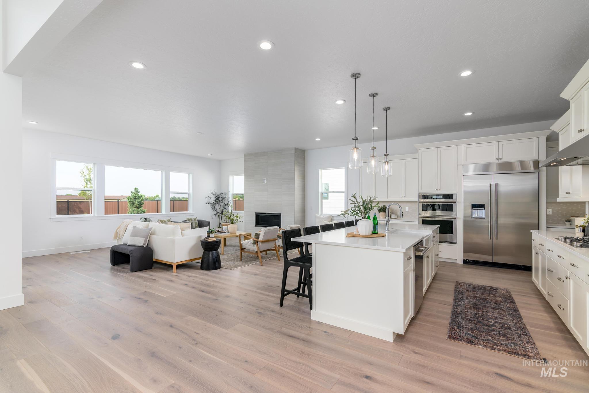 Kitchen with appliances with stainless steel finishes, pendant lighting, a breakfast bar area, an island with sink, and open floor plan