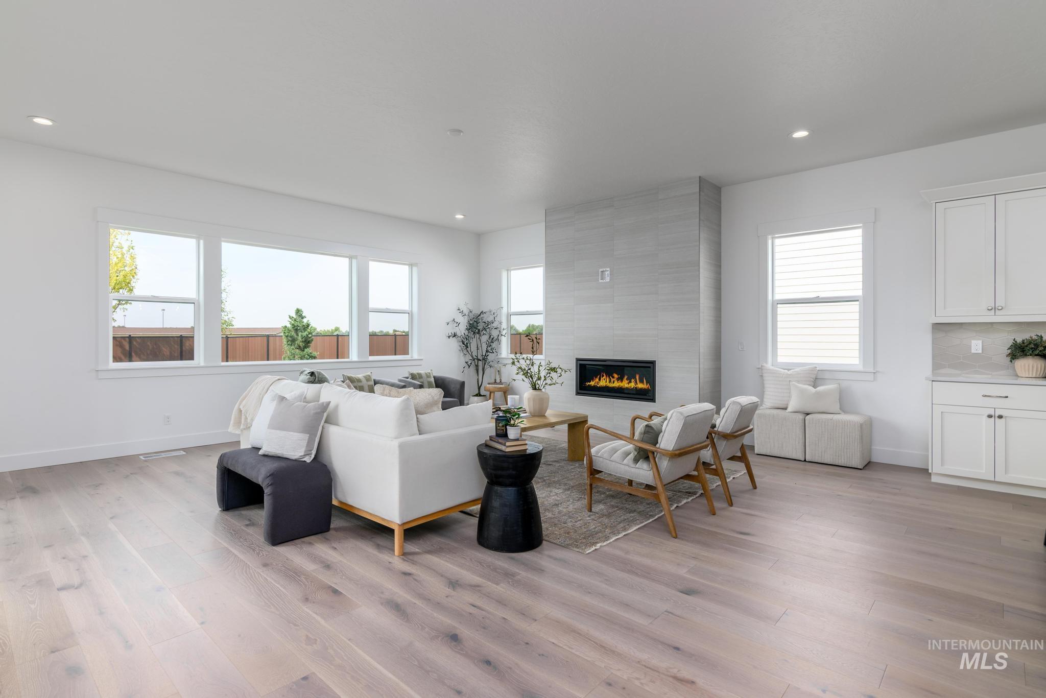 Living room featuring a fireplace, light wood finished floors, and recessed lighting