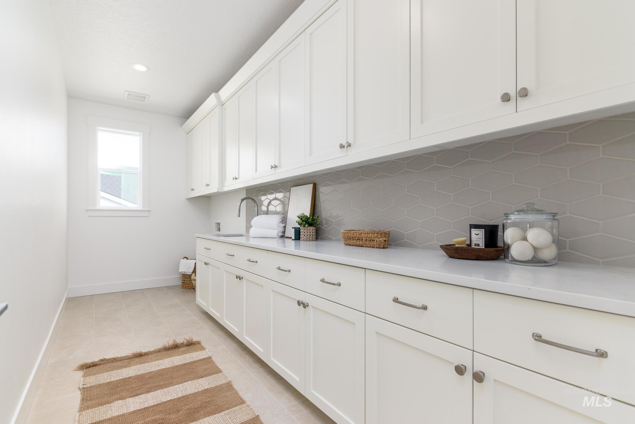 Laundry room featuring light tile patterned flooring and recessed lighting