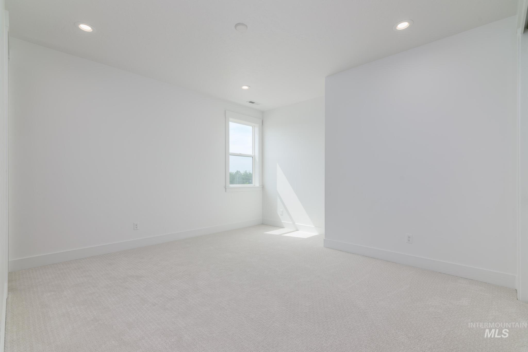 Empty room featuring light carpet and recessed lighting