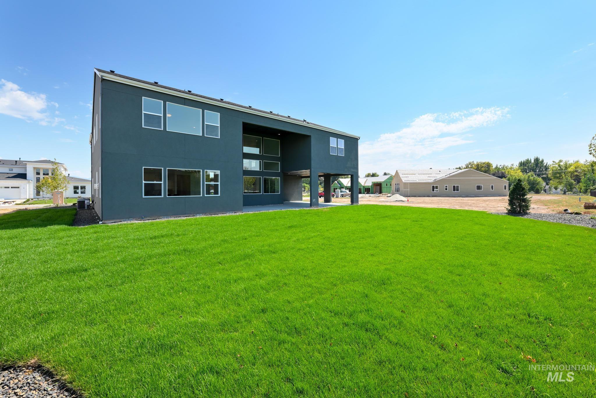 Rear view of house featuring stucco siding, a yard, and a patio area