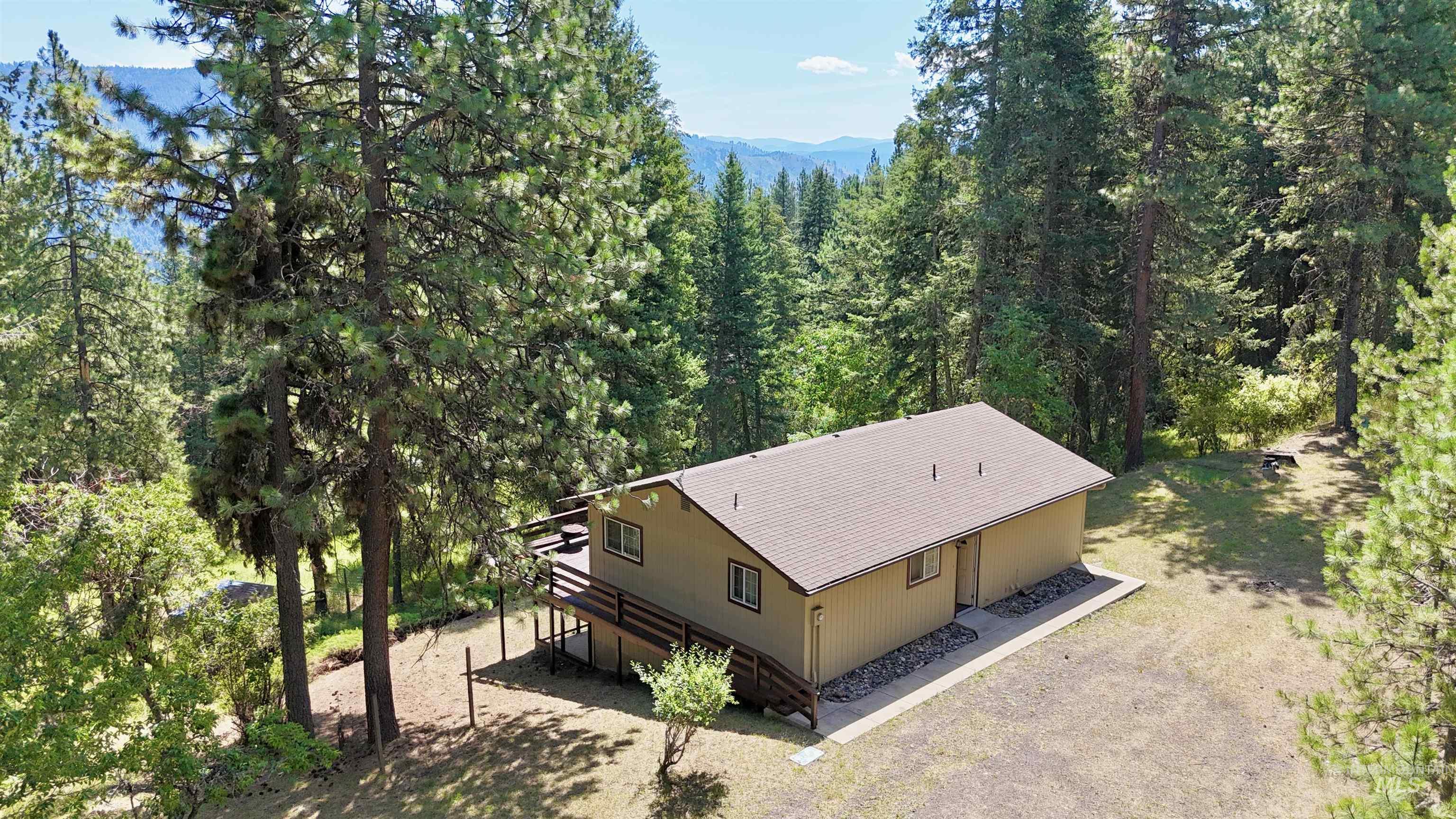 Aerial view of property and surrounding area featuring a heavily wooded area